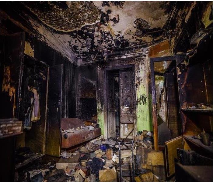 Interior of fire damaged home; heavy smoke, soot, and charred belongings